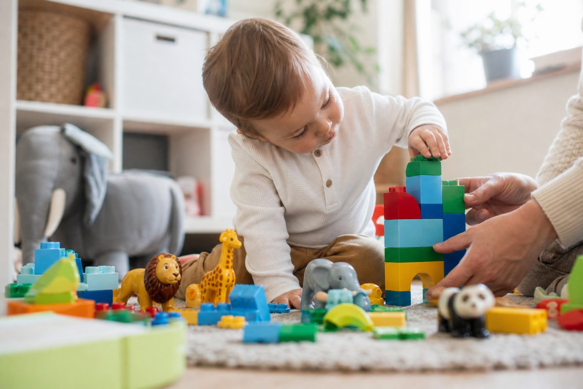 Kisgyerek nagy építőkockákkal játszik Duplo jellegű készlettel