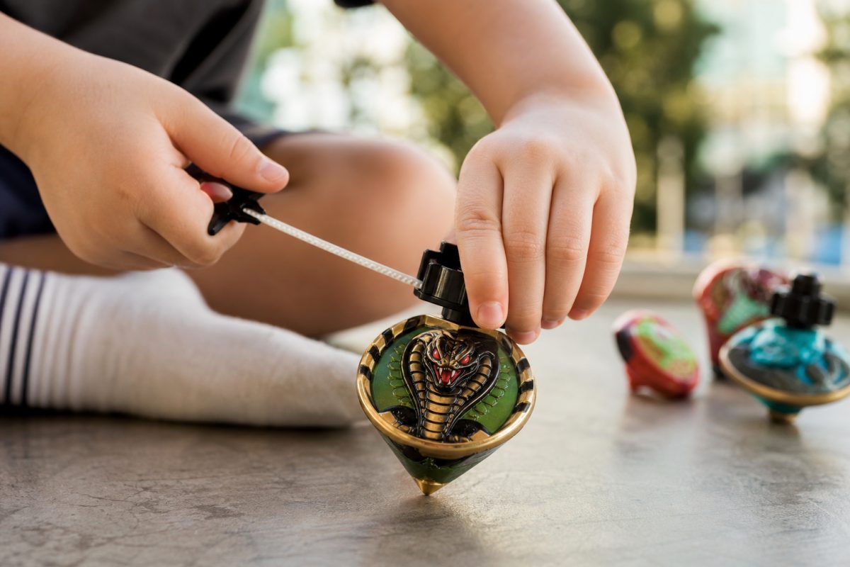 Peonza Cobra jellegű pörgettyű madzaggal feltekerés közben