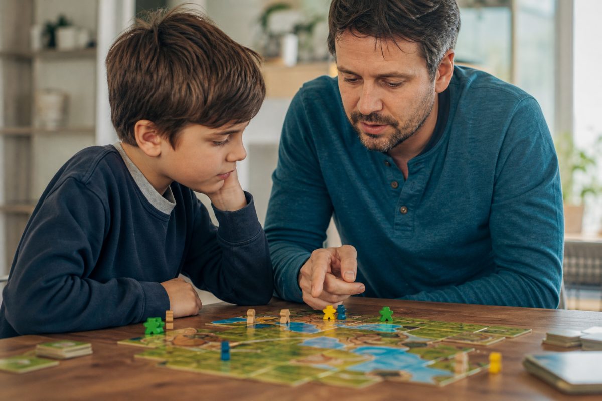 Gyerek és szülő stratégiai társasjáték lépést beszél meg