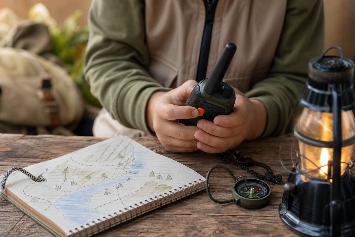 Gyerek kéz walkie-talkie gombját nyomja térképes játék közben